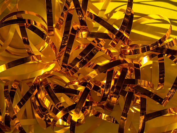 istock Festive yellow background. Golden shimmer shiny ribbon texture glowing decorations backdrop. Holiday Christmas New year. 1292783087