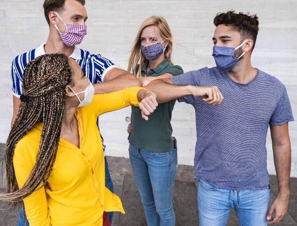 istock Young multiracial people meet and greet with elbow while wearing protective face masks - Prevention for coronavirus and alternative lifestyle 1292783260