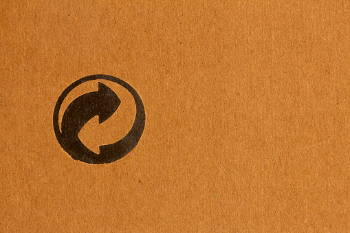 View of Recycle and reuse symbol printed in cardboard. Symbol used in items which are recyclable