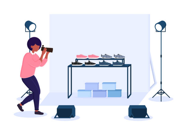 Female photographer in studio doing sneakers commercial photography Female photographer in studio doing sneakers commercial photography. Concept of professional commercial shoot with camera, lights, background and reflectors. Flat cartoon vector illustration cartoon photos stock illustrations