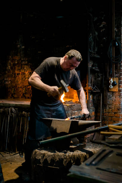istock Blacksmith stands at the anvil and forges metal 1292785262