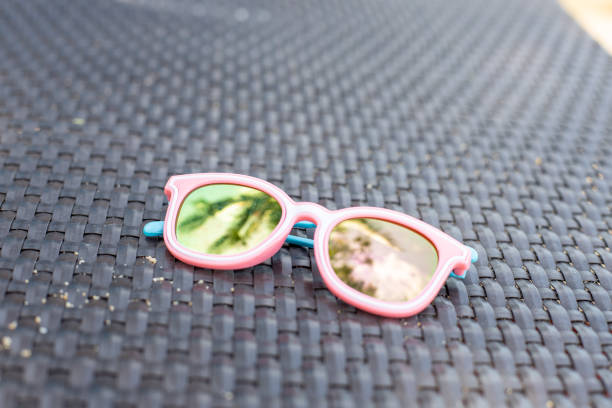 istock kid pink sunglasses with palm reflection laying on sunbed. 1292786449