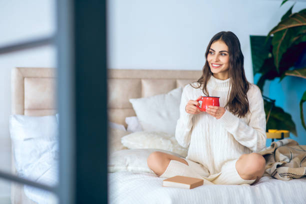 istock Dark-haired woman with a red cup in her hands looking relaxed 1292786830