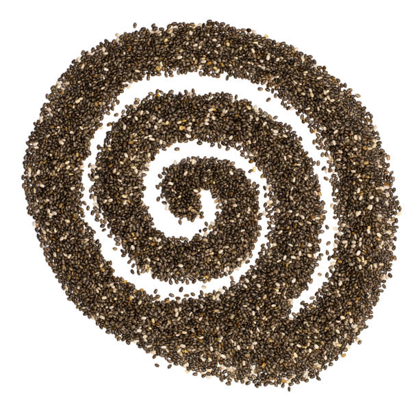 白い背景に分離された抽象的なスパイラルの形で暗いチア種子。スペインセージの小粒 - tablespoon chia healthy eating seed ストックフォトと画像