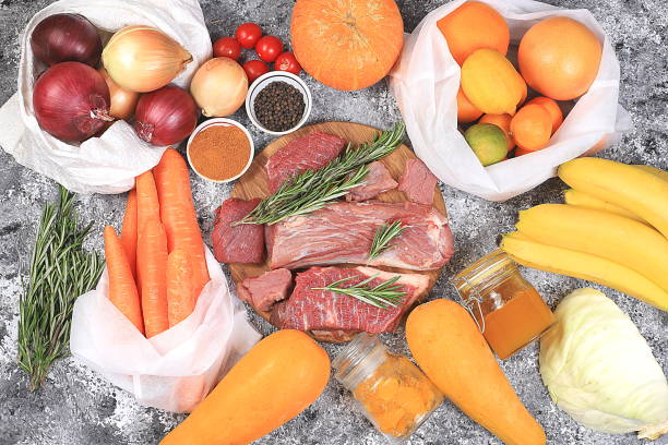 Healthy natural food for diet in eco bags, meat, nuts, and vegetables. Selection of fresh products with vitamin C to strengthen the immune system and lose weight, zero waste concept, food delivery, selective focus alimentos naturales saludables para la dieta en bolsas ecológicas, carne, frutos secos y verduras. selección de productos frescos con vitamina c para fortalecer el sistema inmunológico y perder peso, concepto de cero residuos, entrega de alimentos,
