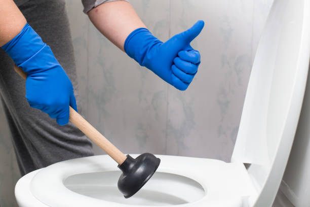 Cleaned stick in toilet. Like with suction cup Hands in gloves holding suction cup and showing thumb up near by toilet bowl. occlusion stock pictures, royalty-free photos & images