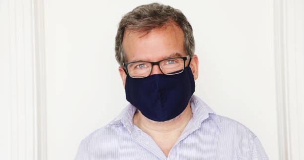 istock Mature man smiling behind protective mask 1292790795