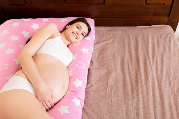 istock Young pregnant woman lying in bed with supportive pillow 1292792683