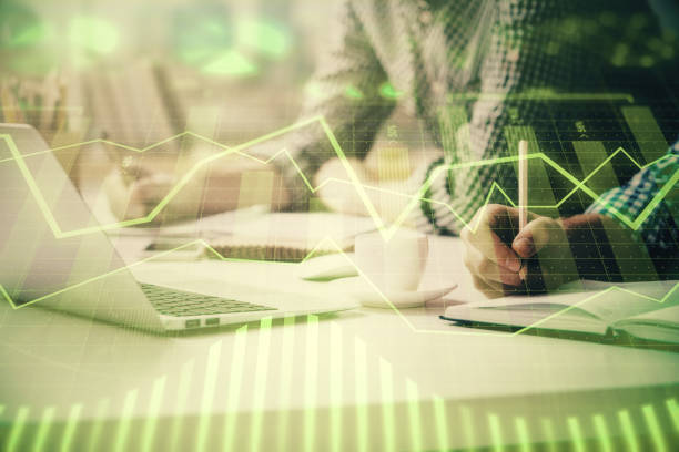 istock Multi exposure of forex chart with man working on computer on background. Concept of market analysis. 1292792803