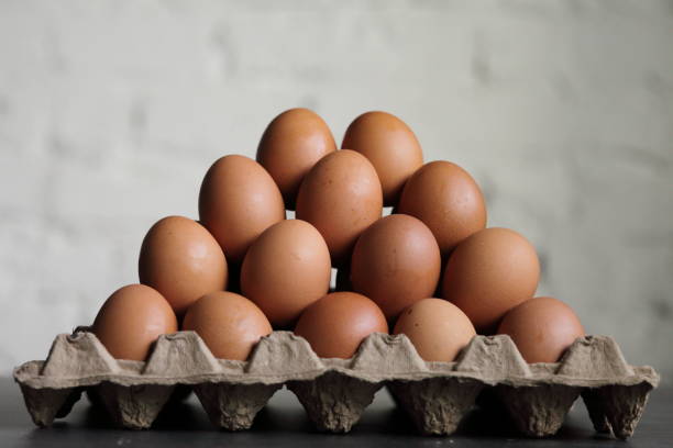 istock Pyramid of chicken eggs on a white wall background 1292797219