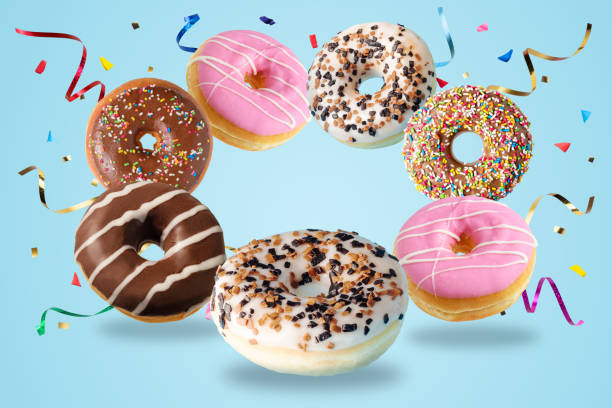 istock Different fresh donuts with confetti on blue background. Minimal food concept. 1292801249