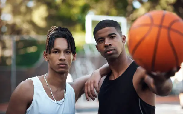 Portrait of two sporty young men standing on a basketball court