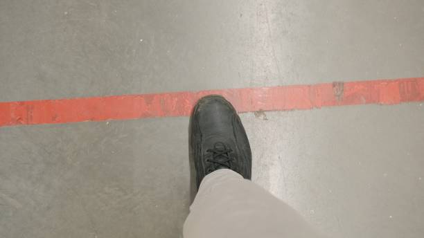 istock Legs stop at red forbidding line 1292805594
