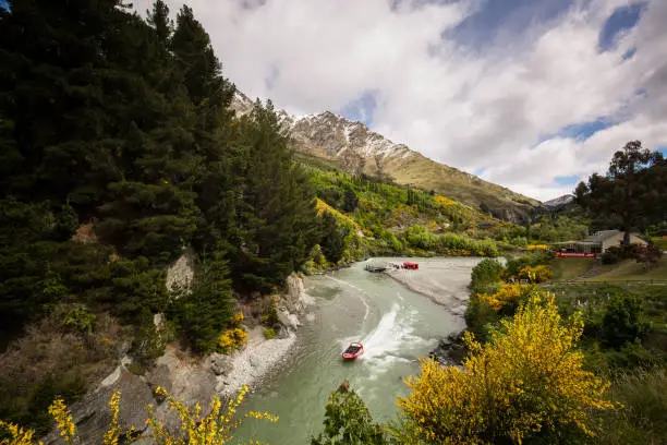Queenstown, New Zealand - November 9, 2017: Jet boat making its way through the famous Shotover River in Queenstown one of the extreme activities that make it such a popular destination.