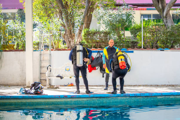 istock Two men on the edge of a pool before jumping into it while their teacher gives them instructions 1292810436