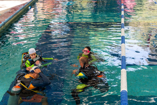 istock a group of four divers with all their equipment on talking inside the pool 1292812290