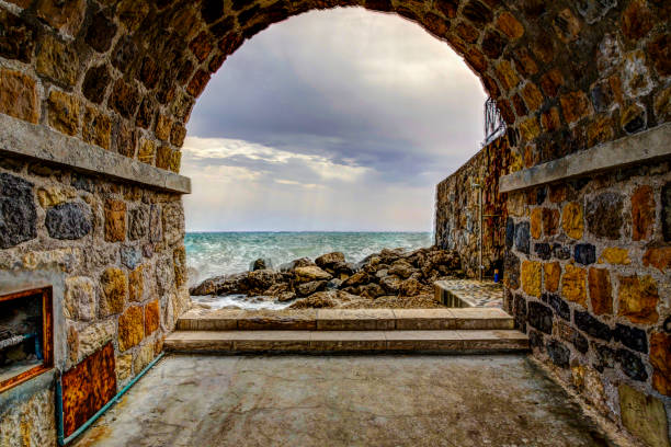 vue sur le bord de mer devant les murs de la forteresse à antibes france - antibes photos et images de collection