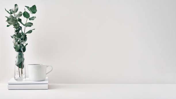 istock A mug, a stack of books, a wooden board and a transparent vase with eucalyptus branches. Eco-friendly materials in interior decor, minimalism. Copy space, mock up 1292812951