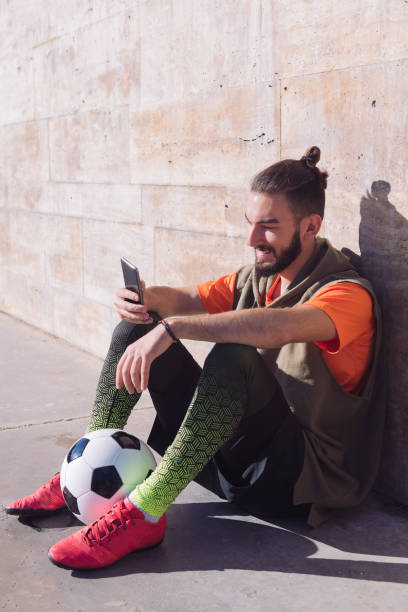 istock soccer player rest consulting his mobile phone 1292813200