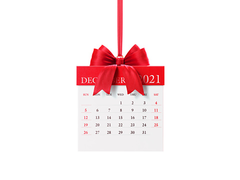 2021 monthly red giftbox shaped calendar: December. Horizontal composition with copy space. Clipping path is included.  The calendar is red in color and hanging from a red ribbon Isolated on white.