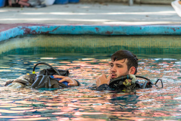 istock diver without his googles helping another to dive into water 1292814862
