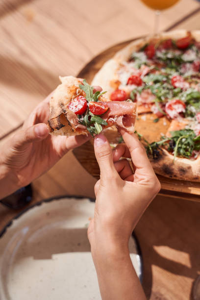 istock Woman hands picking slice of pizza 1292817684