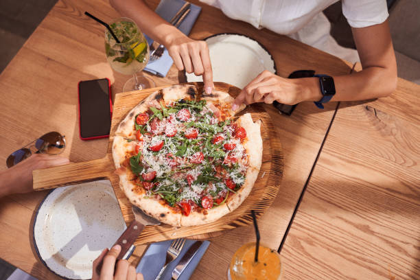 istock Flat-lay of female hands taking pizza 1292817693