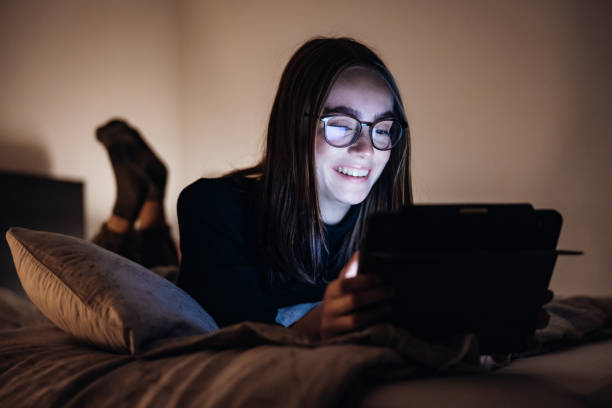 istock Teenage girl having fun relaxing on her Bed using Digital Tablet Computer 1292819595
