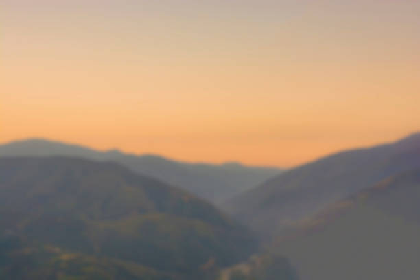 Blurred abstract background of beautiful orange sky with mountains during sunset. Copy space