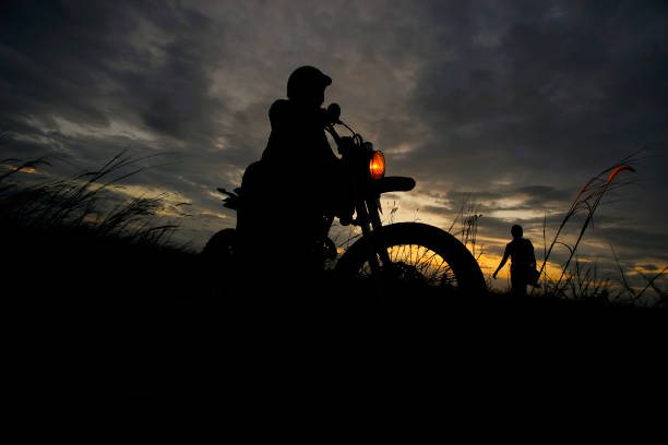 istock Silhouette of a man riding his motorcycle during sunset 1292830924