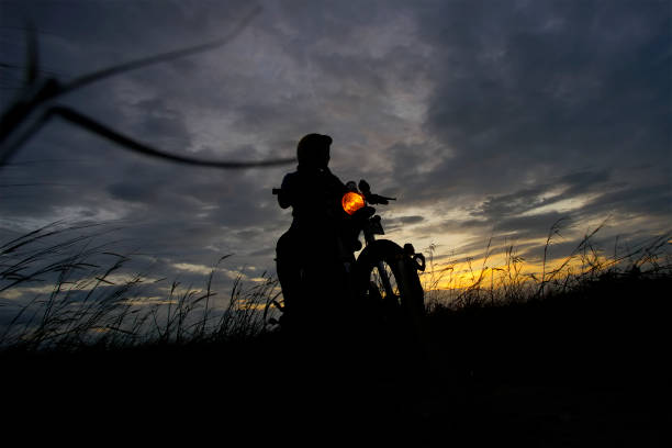 istock Silhouette of a man riding his motorcycle during sunset 1292830934