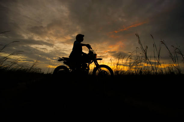 Silhouette of a man riding his motorcycle during sunset