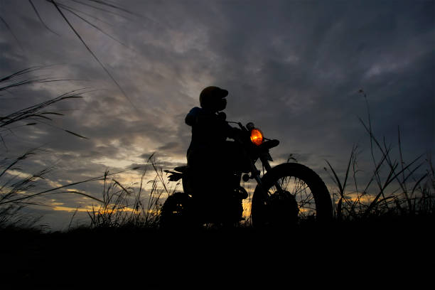 istock Silhouette of a man riding his motorcycle during sunset 1292830955