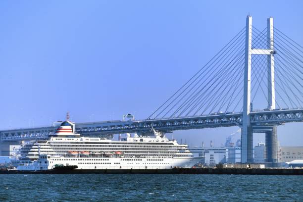 пассажирское судно asuka ii проходит под мостом залива иокогама - cruise passenger ship nautical vessel vacations стоковые фото и изображения
