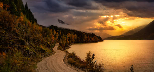 Scenic road in Canadian Nature during Autumn Season Beautiful Panoramic Landscape View of a Scenic road in Canadian Nature during Autumn Season. Dramatic Colorful Sunset Sky. Taken at Lillooet Lake, Pemberton, British Columbia, Canada. pemberton bc stock pictures, royalty-free photos & images