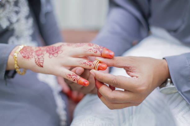 istock Groom put a wedding ring on bride hand 1292835102