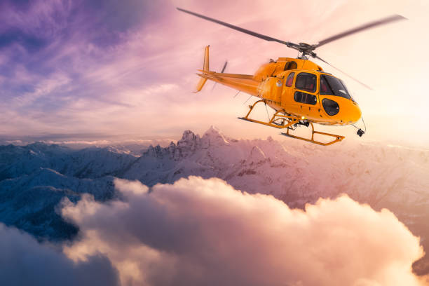 ロッキー山脈の上空を飛行する黄色いヘリコプター - action adventure aerospace industry air vehicle ストックフォトと画像