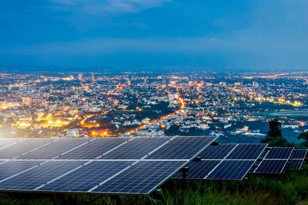 solarpanel mit stadt nacht architektur elektrische energie licht hintergrund, saubere alternative energie-energie-konzept. - solar panel fotos stock-fotos und bilder