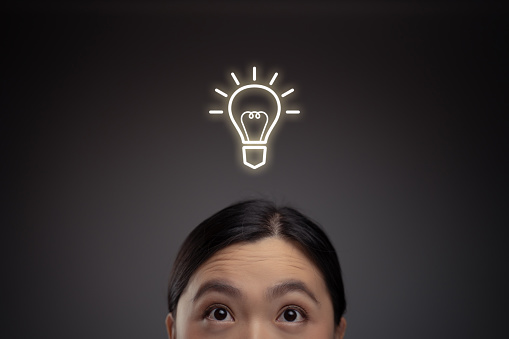 Happy Asian woman and lightbulb icon hologram effect. Isolated on background.