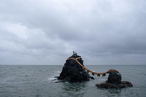 Futami, Mie Prefecture / Japan, October 17 2020: Meoto Iwa (Married Couple Rocks). Two rocky stacks in the sea. They are joined by a shimenawa and are considered sacred by worshippers at the neighboring Futami Okitama Shrine