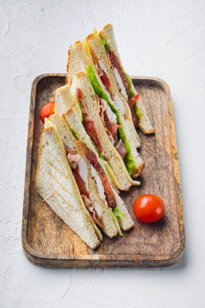 homemade club sandwich made with turkey, bacon, ham, tomato, on white background - sandwich club sandwich ham turkey imagens e fotografias de stock