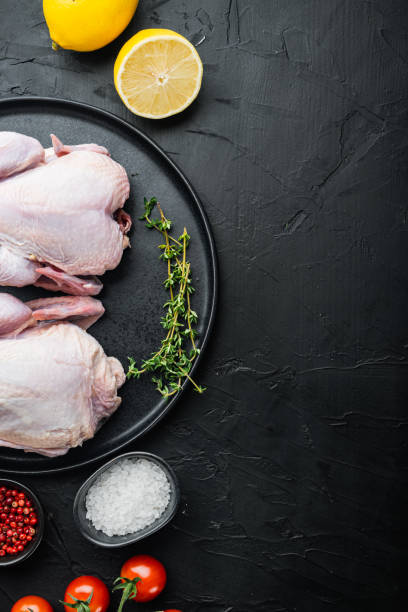 istock Whole raw free range chicken with herbs spices ingredients, on black background, top view with copy space for text 1292853389