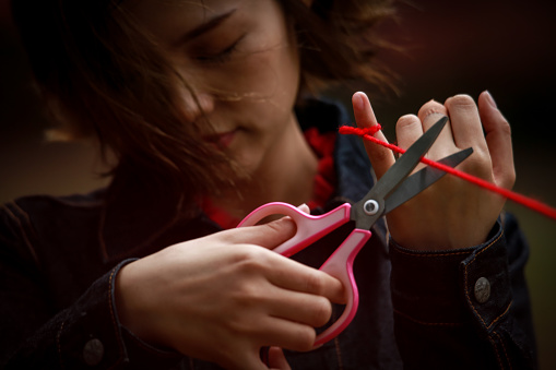 Woman cutting red thread