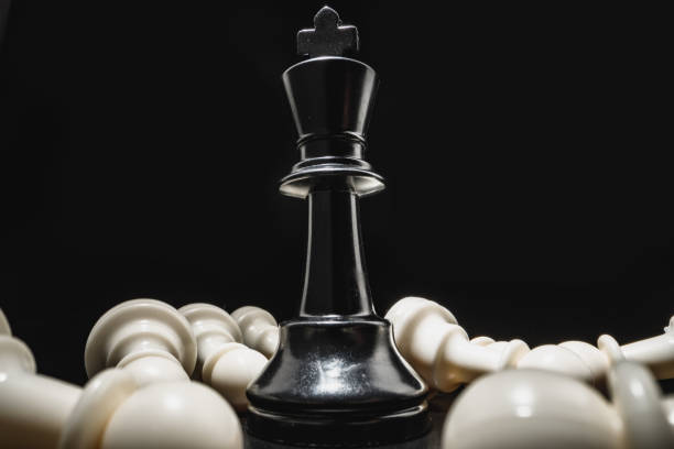 istock Chess game with chess pieces against black background 1292859385