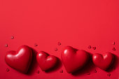 Valentine’s day composition with red hearts, photo template on deep red background.