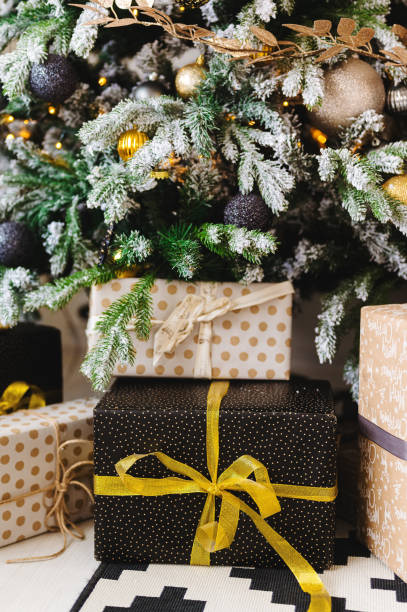 istock gifts in beige and black boxes under the christmas tree 1292862478