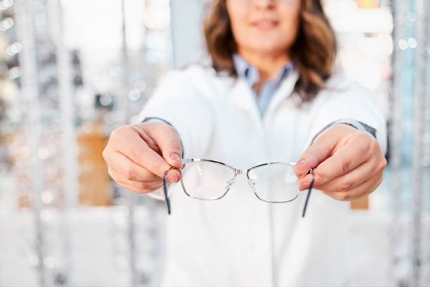 istock Optician showing and suggesting eyeglasses in optical shop 1292871268