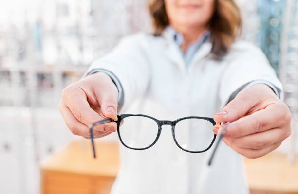 istock Optician showing and suggesting eyeglasses in optical shop 1292871271
