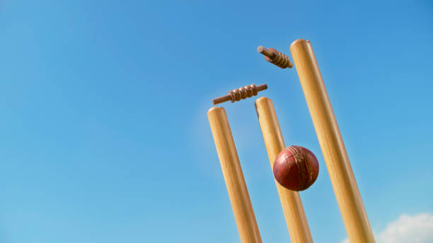 Cricket ball hitting the stumps Cricket ball hitting the stumps and knocking off the bails against sky. cricket stump stock pictures, royalty-free photos & images