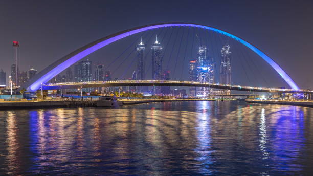 istock Futuristic Pedestrian Bridge over the Dubai Water Canal Illuminated at Night , UAE 1292876089